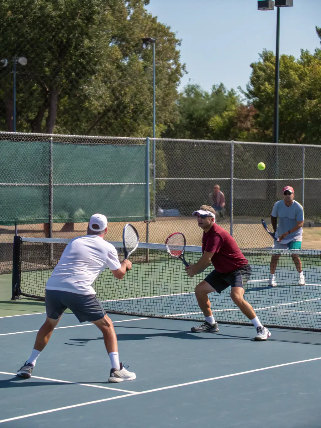 A group of adult tennis players participating in a doubles match at CENT DEPARTEMENTAL DE TENNIS, showcasing the social and competitive aspects of the adult programs.